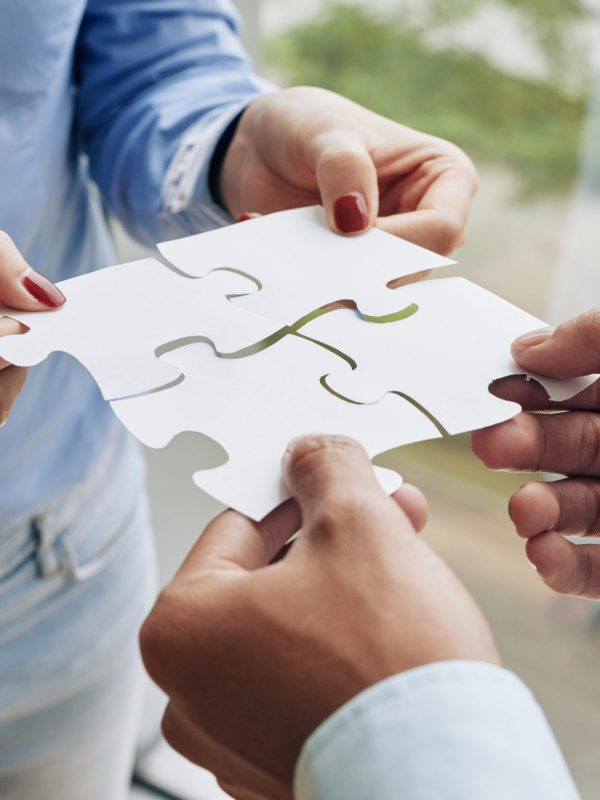 Close-up image of business people assembling puzzle